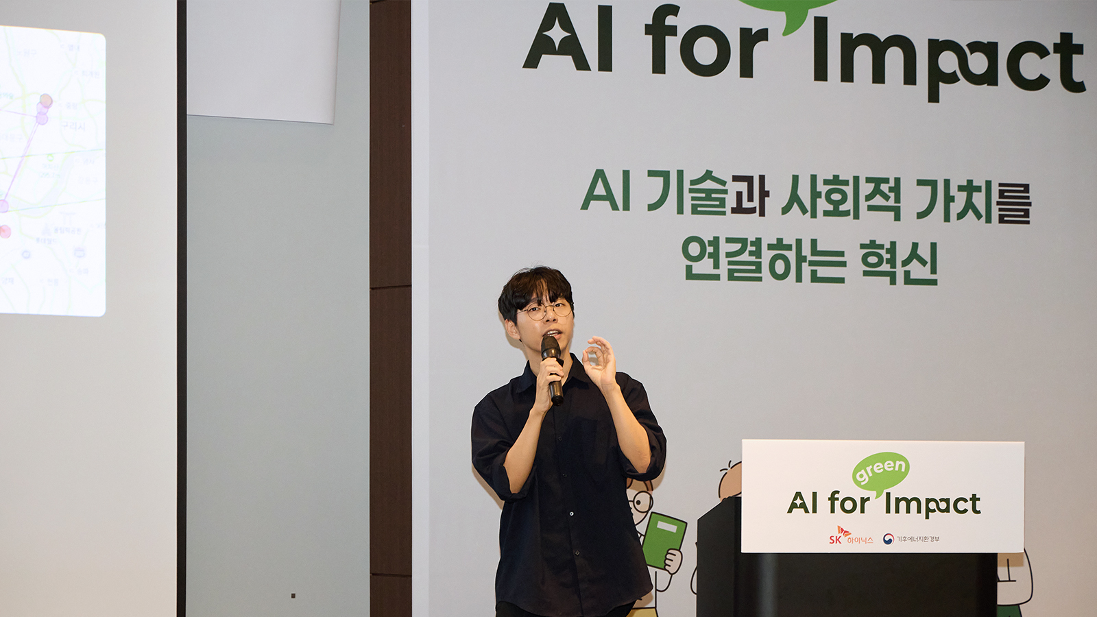 SK하이닉스와 기후에너지환경부가 개최한 'AI for Impact' 행사에서 발표자가 마이크를 들고 AI 기술과 사회적 가치를 주제로 설명하고 있다.