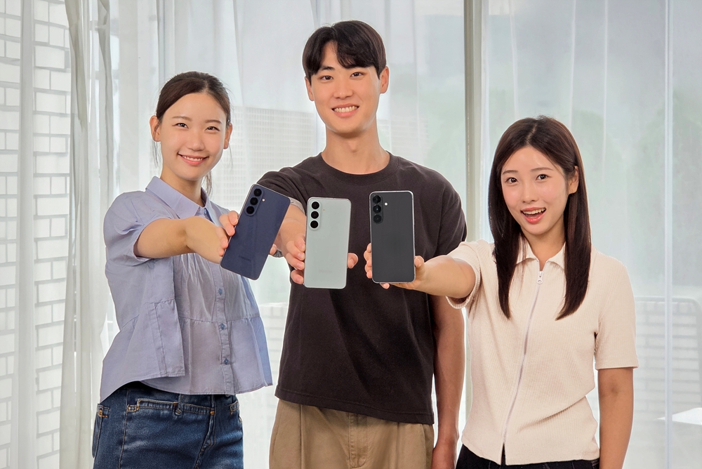 모델 3명이 각기 다른 색상의 갤럭시 S26 FE 스마트폰을 들어 보이며 웃고 있다.