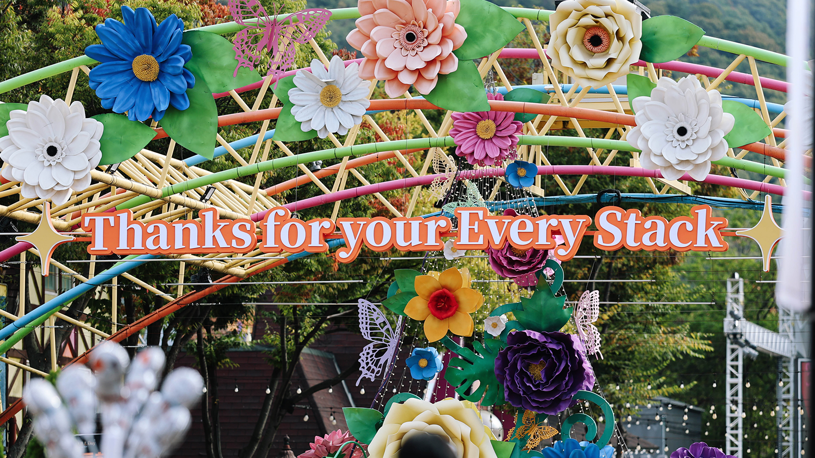 알록달록한 조화 장식 아치에 'Thanks for your Every Stack' 문구가 걸려 있다.