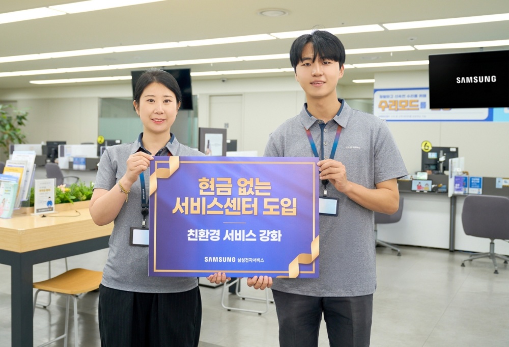 삼성전자서비스 직원들이 '현금 없는 서비스센터 도입, 친환경 서비스 강화' 문구가 적힌 안내판을 들고 있다.