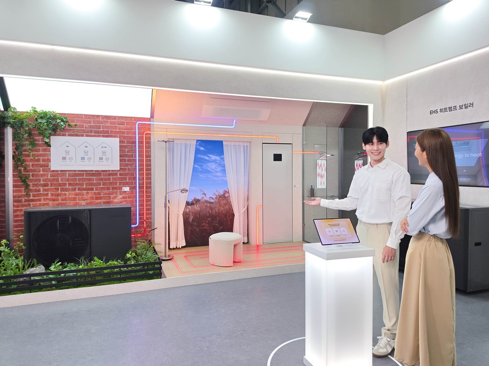 모델이 EHS 히트펌프 보일러 전시 공간에서 실내 난방 배관 구조를 설명하며 관람객에게 소개하고 있다.
