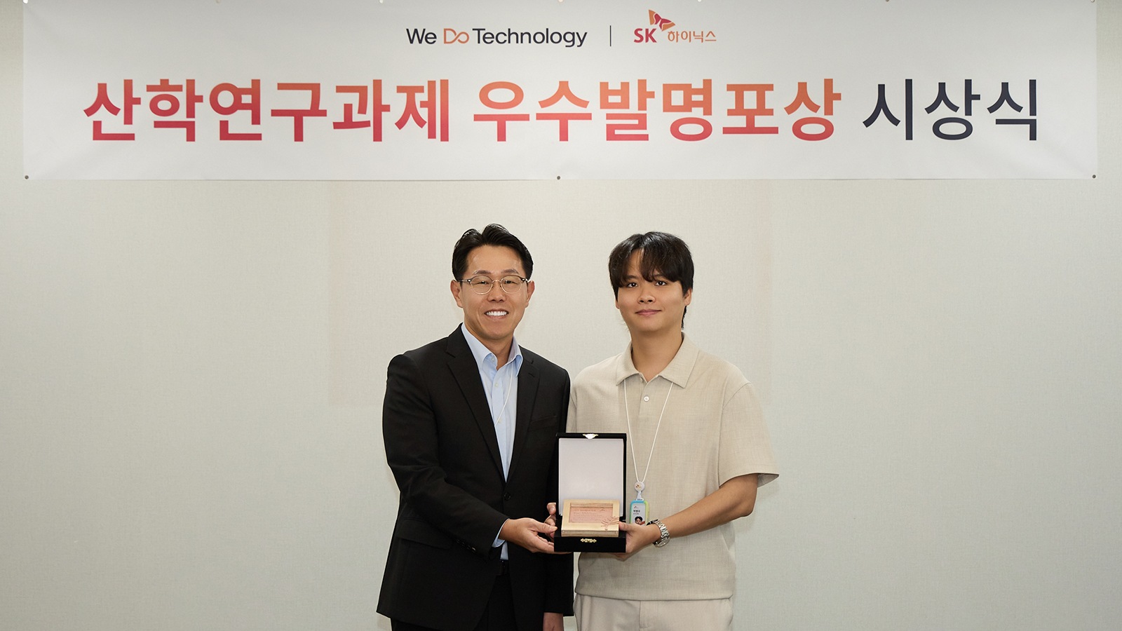 SK하이닉스 관계자가 산학연구과제 우수발명 시상식에서 수상자에게 상패를 전달하며 기념 촬영하는 모습.