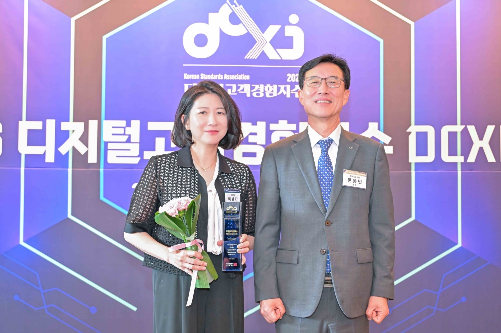 삼성전자 관계자가 '2025 디지털고객경험지수(DCXI)' 시상식에서 트로피와 꽃다발을 들고 관계자와 기념 촬영을 하고 있다.
