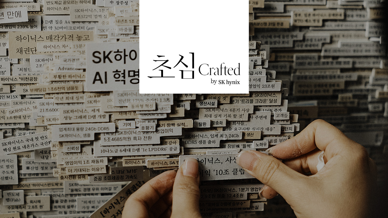 SK하이닉스 관련 신문 헤드라인 조각들을 쌓아 손으로 다루는 모습과 '초심 Crafted by SK hynix' 문구.