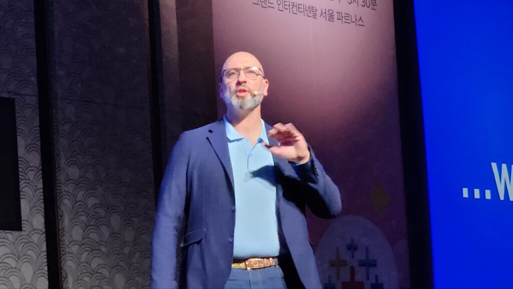 헤드셋 마이크를 착용한 발표자가 무대에서 손짓하며 태블로 컨퍼런스에서 발표하고 있다.