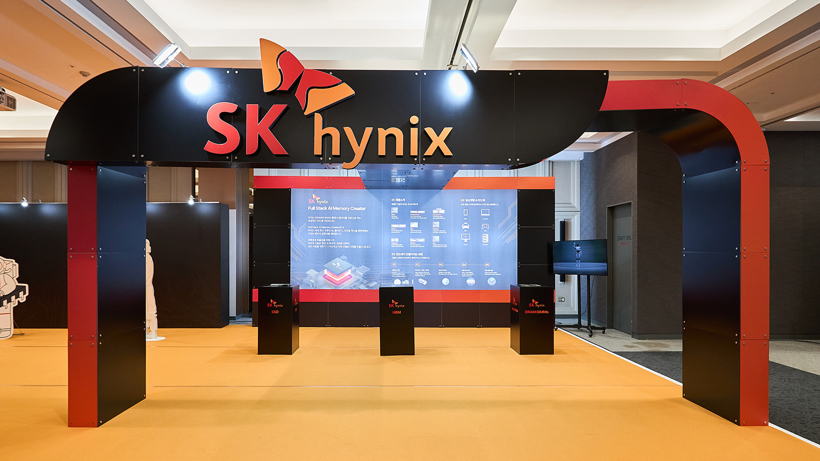 전시장에 마련된 SK하이닉스 부스 입구와 SSD, HBM, DRAM DIMMs 제품을 소개하는 대형 스크린.