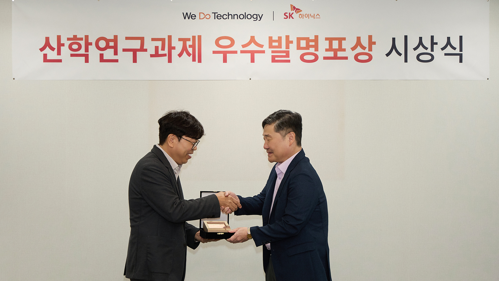 SK하이닉스 산학연구과제 우수발명포상 시상식에서 관계자들이 상패를 전달하며 악수하는 모습.