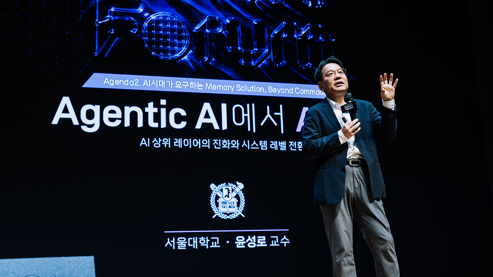 서울대 윤성로 교수가 마이크를 들고 'Agentic AI'를 주제로 발표하는 모습, 배경에 AI 메모리 솔루션 관련 화면.