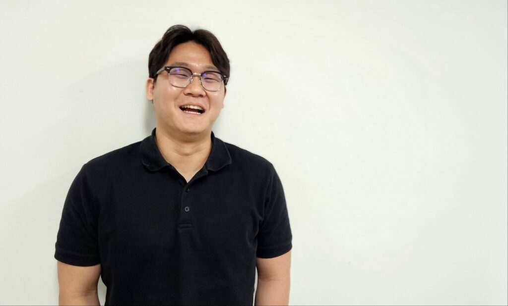 안경을 쓴 검은색 폴로셔츠 차림의 유준하 오토랩스 대표가 밝게 웃으며 인터뷰에 응하고 있다.