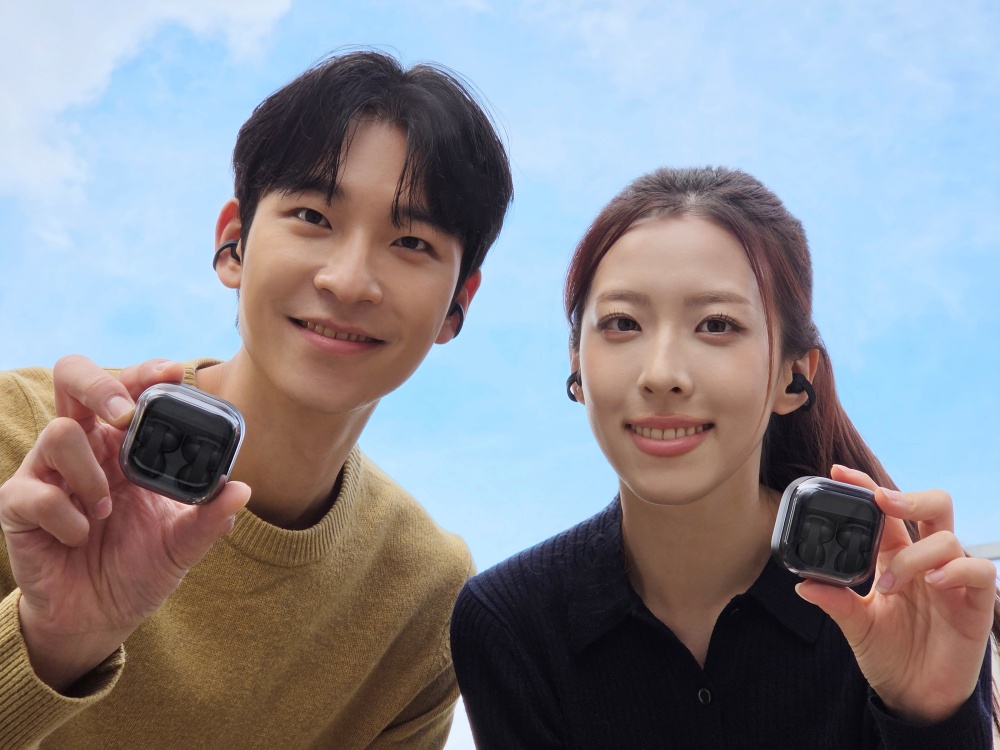 모델들이 '갤럭시 버즈 온' 케이스를 들고 귀에 착용한 모습을 보여주며 제품을 소개하고 있다.